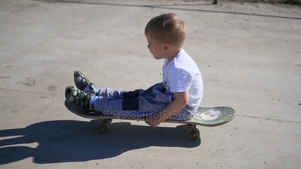 Een klein kind rijden op een skateboard. Actieve outdoor sporten — Stockvideo