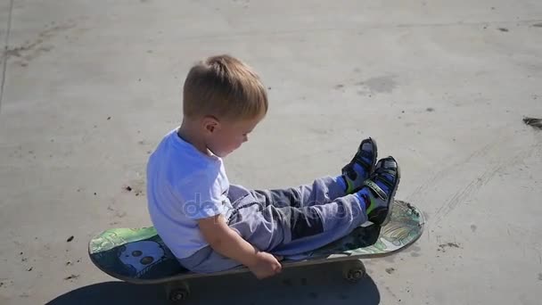 Маленька дитина катається на скейтборді. Активний спорт на відкритому повітрі — стокове відео