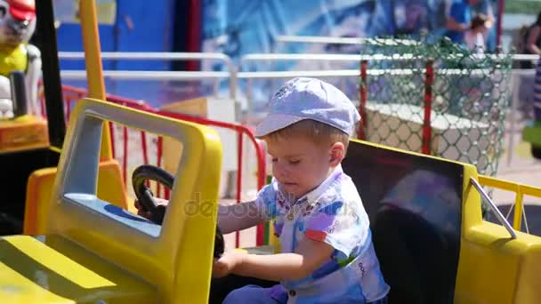 Niño que se divierte en un parque de diversiones. — Vídeos de Stock