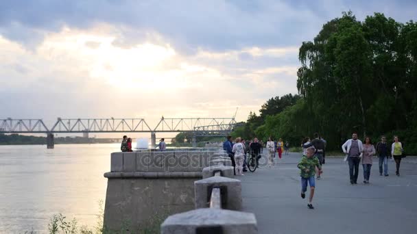 Novosibirsk, Rusya - 5 Haziran 2017: İnsanlar yürüyüşler mesire akşam. Bulutların arasından güneş ışınları — Stok video
