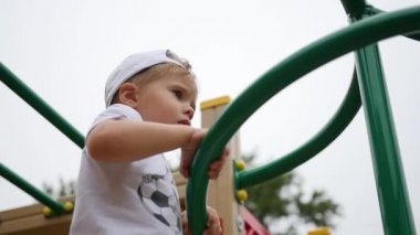 Sahada oynayan çocuk merdivenlerden yukarı geliyor. Etkin açık spor