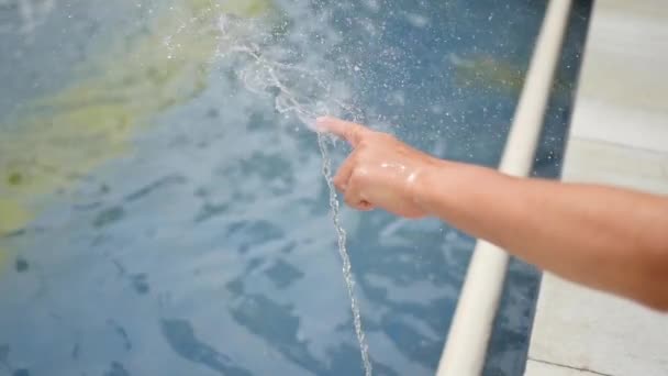 Ett barn leker med vattenstråle i fontänen. Solig sommardag. Kul och spel utomhus — Stockvideo