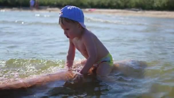 Ein glückliches Kind schwimmt im Meer. Spiel und Spaß im Freien — Stockvideo