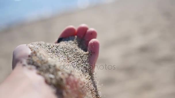 Sand, der aus der Hand fällt. Unterhaltung und Spiele im Freien — Stockvideo