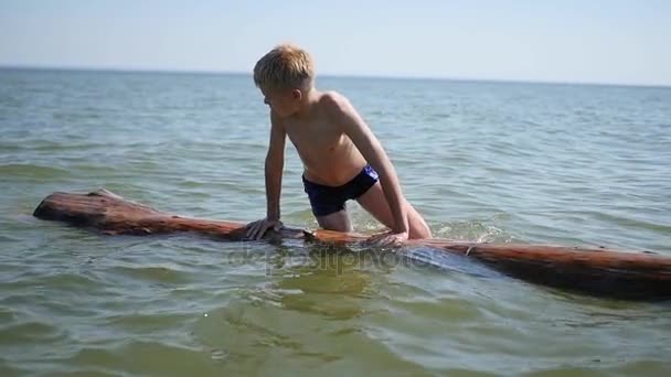 Ein glückliches Kind schwimmt im Meer. Spiel und Spaß im Freien — Stockvideo