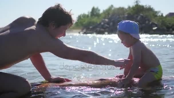 Un niño feliz nada en el mar. Diversión y juegos al aire libre — Vídeos de Stock