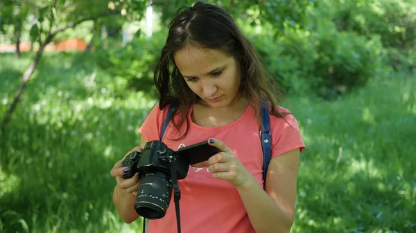 Mladá dívka držící fotoaparát. Představují pro fotoaparát. Zábava venku — Stock fotografie