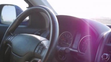 adam, güneşli bir günde bir araba kullanıyor. Günbatımı zamanını. El ve direksiyon simidi portre