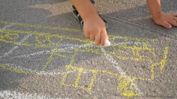 Gezin met kind trekt met krijt op het asfalt. spelletjes buiten — Stockvideo