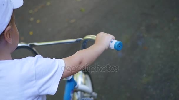 Un niño montando una bicicleta infantil de cerca — Vídeos de Stock