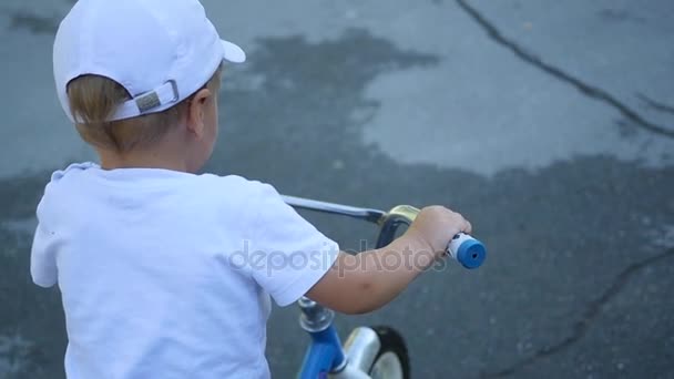 Un bambino in sella a una bici per bambini primo piano — Video Stock