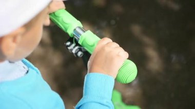 mutlu bir çocuk onun scooter Park.Fun havada sürmek. Eller yakın çekim