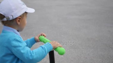 mutlu bir çocuk onun scooter Park.Fun havada sürmek. Yakın çekim