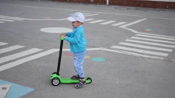 Seorang anak yang bahagia mengendarai skuternya di Park.Fun outdoors — Stok Video