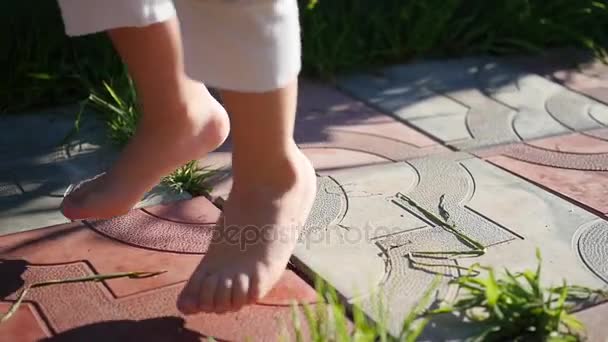Os pés descalços das crianças correm ao longo do caminho. Diversão ao ar livre — Vídeo de Stock