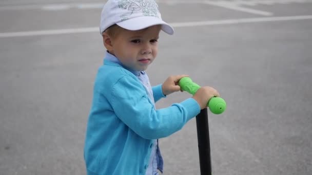 Uma criança feliz monta sua scooter no Park.Fun ao ar livre — Vídeo de Stock