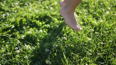 Çimlerin çalışan çocuk çıplak ayak. Açık havada eğlence