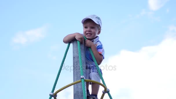 Niño jugando en el patio de recreo, subiendo las escaleras. Deportes activos al aire libre — Vídeos de Stock