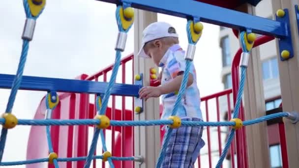 Niño jugando en el patio de recreo, subiendo las escaleras. Deportes activos al aire libre — Vídeos de Stock