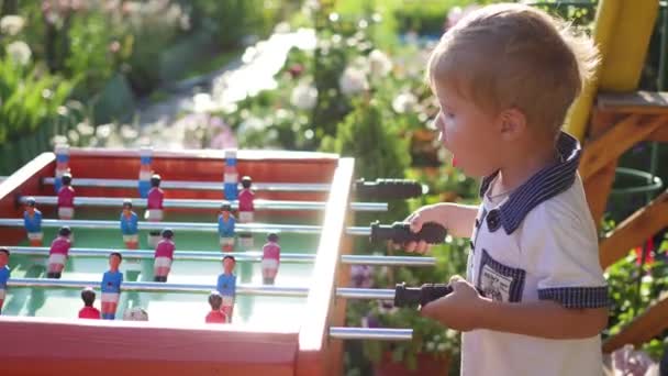 屋外テーブル ・ フットボールで遊ぶ子供たち屋外の楽しみ — ストック動画