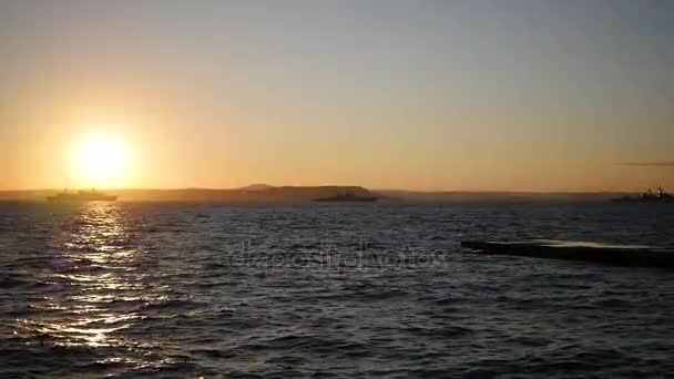 Panorama över vackra solnedgången vid havet. Militära fartyg till sjöss vid solnedgången — Stockvideo