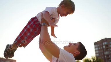 Ağır çekim. genç bir baba havada onun gülen bebek kusuyor. Açık Rekreasyon