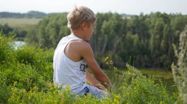 genç bir adam Nehri'nin kıyısında oturuyor. Güzel yaz manzara