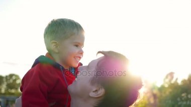 Genç bir baba çocuğunu onun kollarında tutar. Hassasiyet ve sevgili babam benimsemesi. Açık hava etkinlikleri