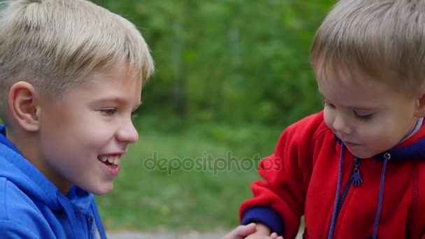 Pequeño bebé tiernamente abrazando y besando a su hermano mayor. niño abrazando a su hermano menor — Vídeo de stock