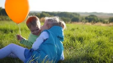 Mutlu çocuklar Park.Boy içinde oyun hugs ve kardeşini öper. Balon. Kahkaha ve çocukların gülümsüyor
