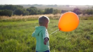 Mutlu çocuk parkta bir balon ile çalışan. Yürüyüş ve açık hava eğlence