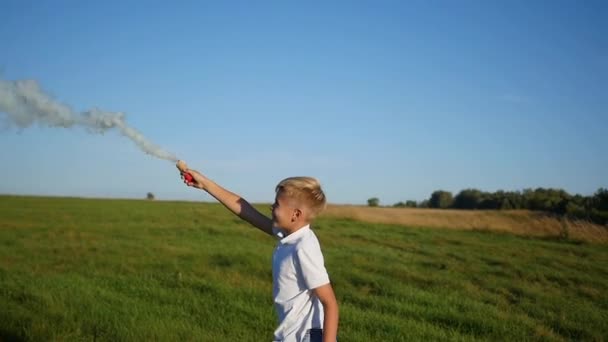 El chico sostiene el humo de color. Diversión en el Parque — Vídeos de Stock