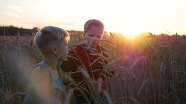 Buğday tarlasında çocuklar hazır. İki çocuk gülmek ve gülümsemek. Temiz havada yürüyüşler