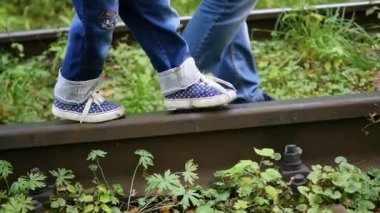 Portre. Tren rayları üzerinde bacaklarım. Adam bir çocuk demiryolu yürüme tutar