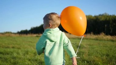 Mutlu çocuk parkta balon ile oynuyor. Yürüyüş ve açık aktiviteler