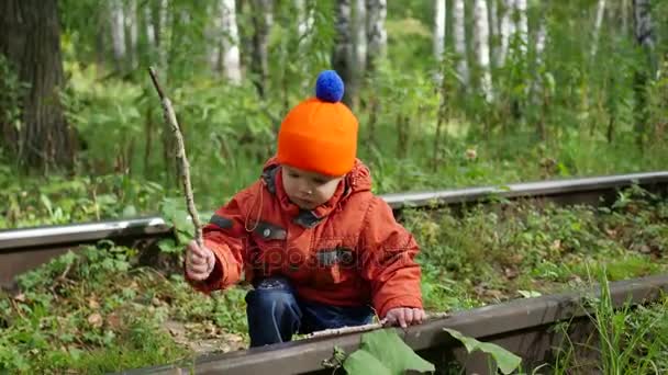 Einsamer Junge, der auf den Bahngleisen spielt. Gefährliche Spiele und Unterhaltung — Stockvideo