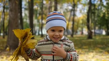 Sonbaharda çocuk eğlence parkı yaprakları ile oynarken temiz havada yürür