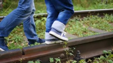Portre. Tren rayları üzerinde bacaklarım. Adam bir çocuk demiryolu yürüme tutar