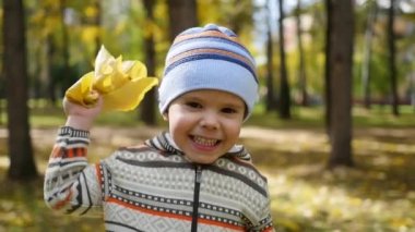 Sonbaharda çocuk eğlence parkı yaprakları ile oynarken temiz havada yürür