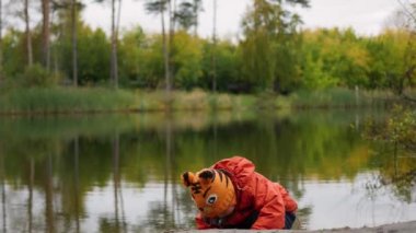 Gölün kıyısında oynayan bir çocuk. Temiz havada yürüyüşler. Sonbahar manzara. Gökyüzü ve Gölü nün su ağaçlarda yansımasıdır. Çok güzel manzaralı bir yer