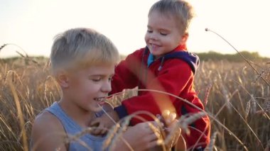 Buğday tarlasında çocuklar hazır. İki çocuk gülmek ve gülümsemek. Temiz havada yürüyüşler