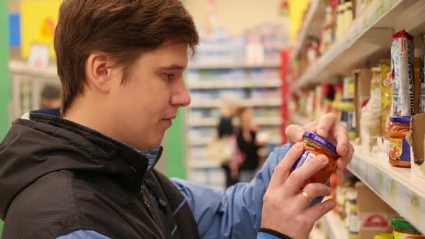 NOVOSIBIRSK, RÚSSIA - 3 de outubro de 2017: O cara da loja seleciona comida — Vídeo de Stock