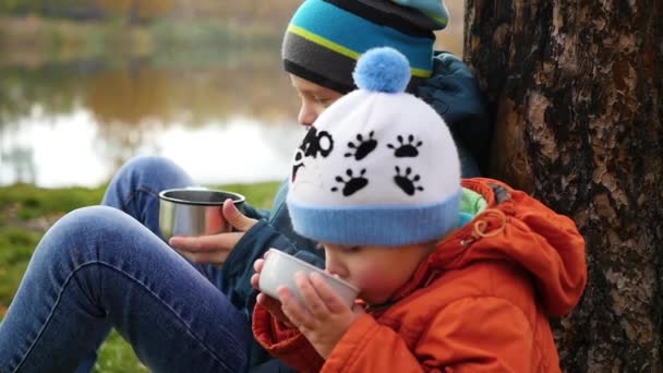在秋园的孩子，坐在草坪和喝热茶，走在清新的空气 — 图库视频影像