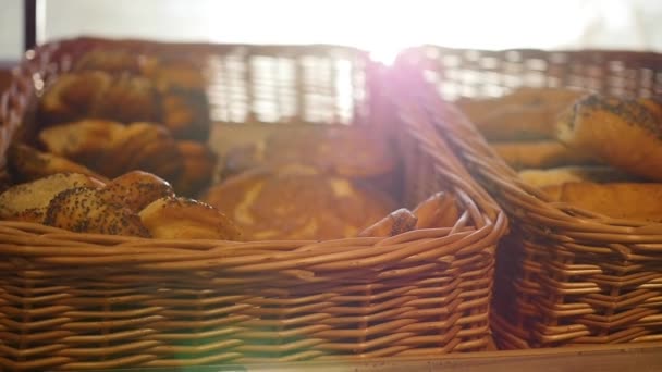 Pâtisseries fraîches dans un panier en vitrine, dans le magasin. Rayons de soleil à travers les pâtisseries — Video