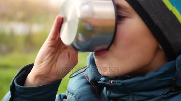 V podzimní Park chlap sedí na trávníku a pít horký čaj procházka na čerstvém vzduchu. Closeup — Stock video