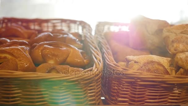 Pasteles frescos en una canasta en escaparate, en la tienda. Rayos de sol a través de pasteles — Vídeo de stock