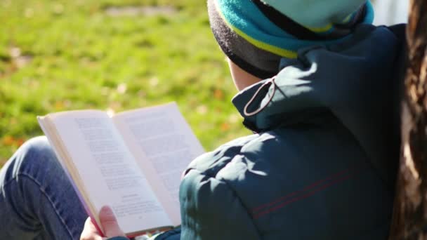 Menino no outono Parque perto do lago lendo um livro. Uma bela paisagem de outono. Educação escolar — Vídeo de Stock