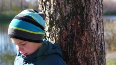 Sonbahar Park bir kitap okuma Gölü yakınındaki çocuk. Güzel bir sonbahar manzara. Okul eğitimi