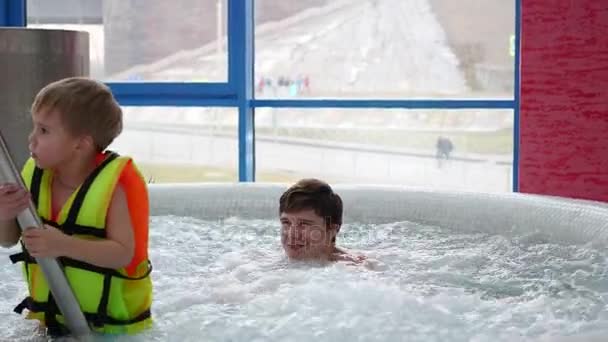 En ung Fader med ett barn simmar i Spa-poolen. Avkoppling och kul i poolen — Stockvideo