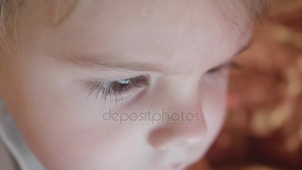 Rosto e olhos close-up de uma criança pequena. Hora da noite. A reflexão da luz nos olhos de uma criança . — Vídeo de Stock